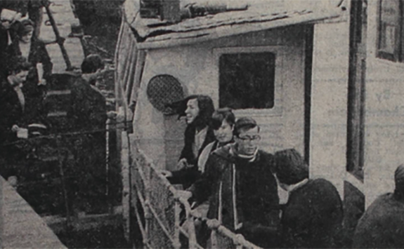 A black and white photograph of students getting on a boat on the River Tyne